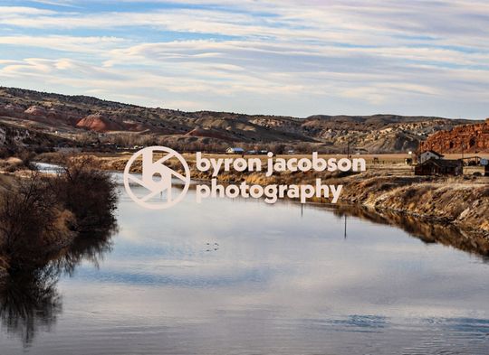 Byron’s logo placed on a Wyoming river with a view of a townscape
