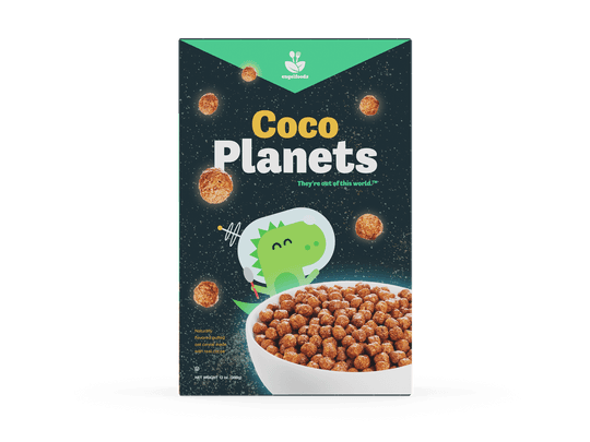 A front view of the box that features a green dinosaur wearing a retro astronaut helmet in outer space gleefuly holding a tiny spoon behind a big bowl of cocoa cereal. Cocoa spheres float and glow as if they were planets. Reads: “Coco Planets: They’re out of this world.™” Also has some additional important legal info about food type and net weight.